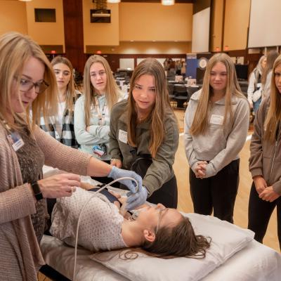 A group of students observing a healthcare demonstration